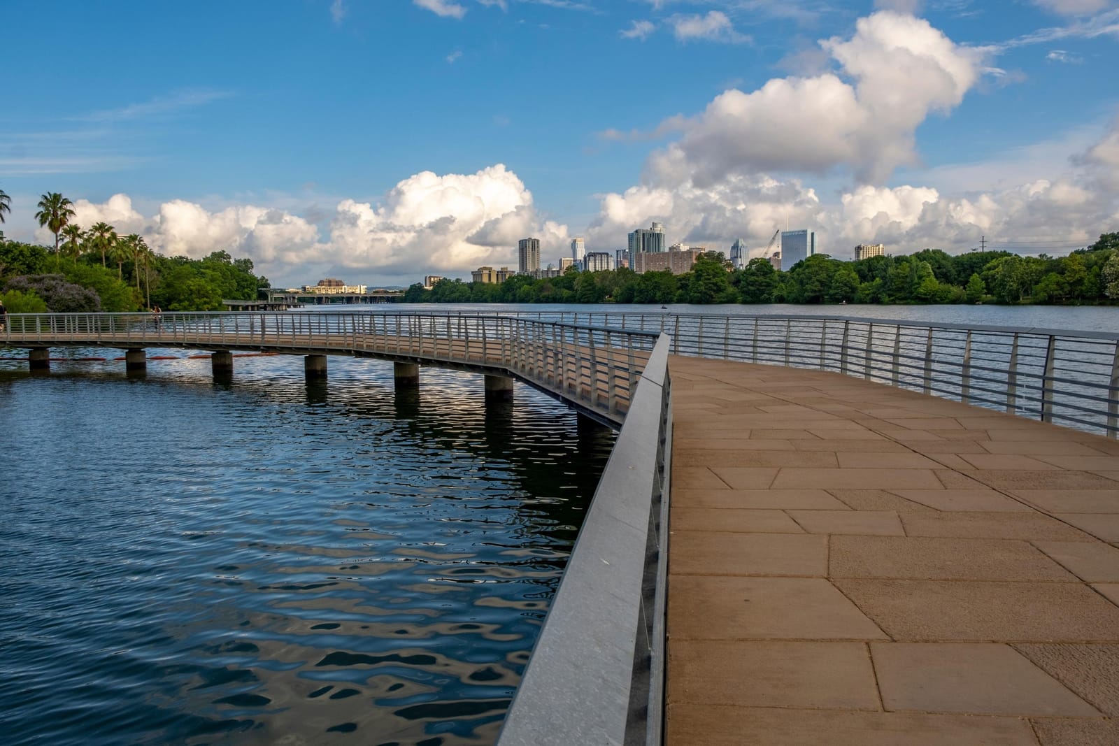 The Lady Bird Lake boardwalk curving over the water, with the Austin skyline in the distance